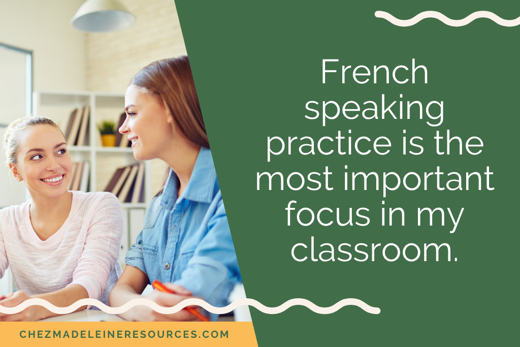 Two female students sitting in a classroom and smiling. They are using French conversation starters to speak in French. The text reads "French speaking practice is the most important focus in my classroom."